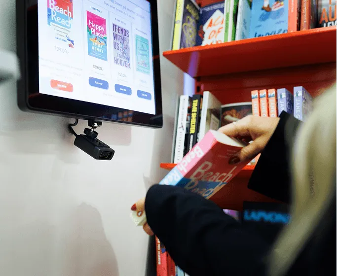 Customer using a Woopz price checker at Akademika