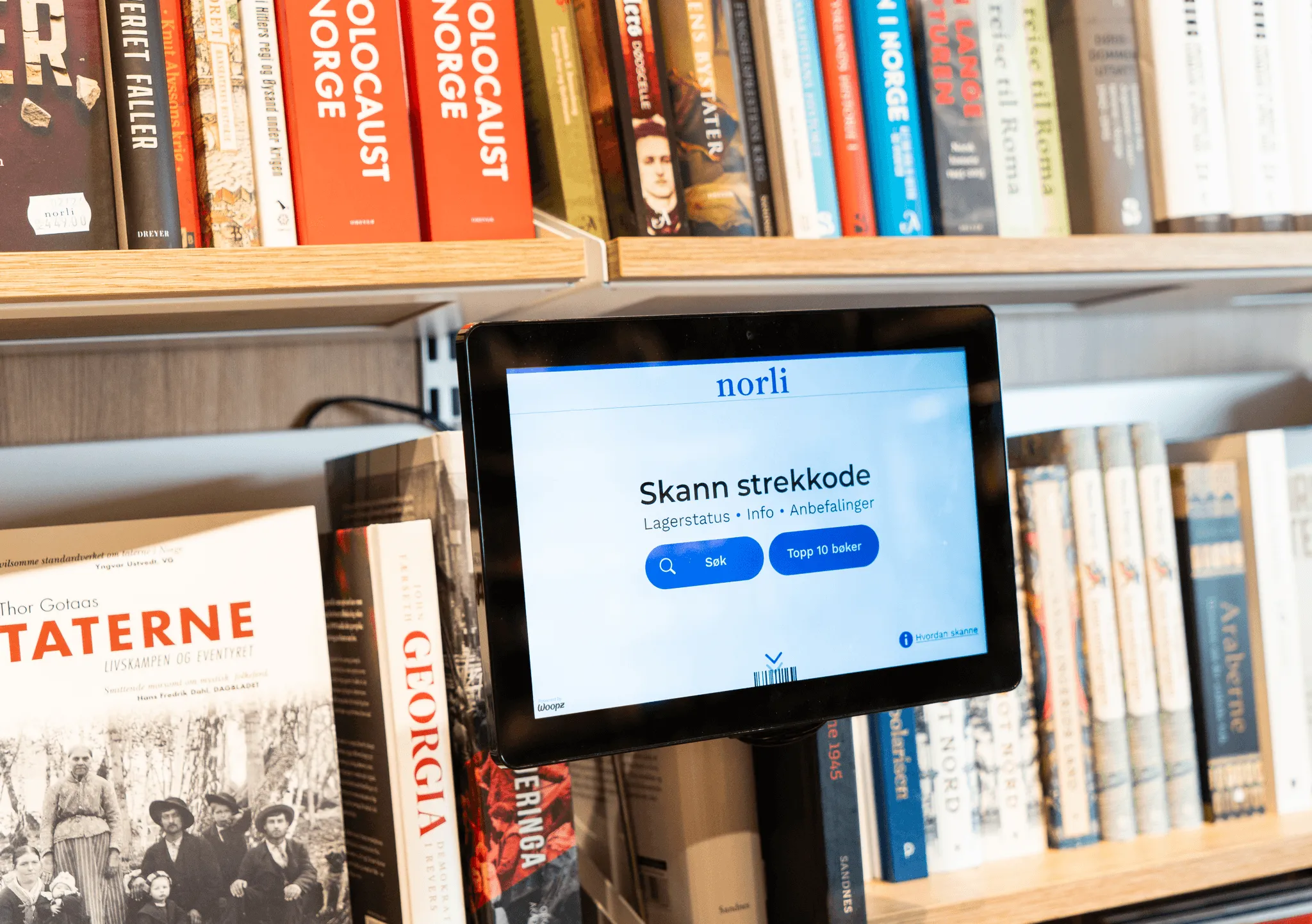 Woopz price checker between bookshelves at Norli